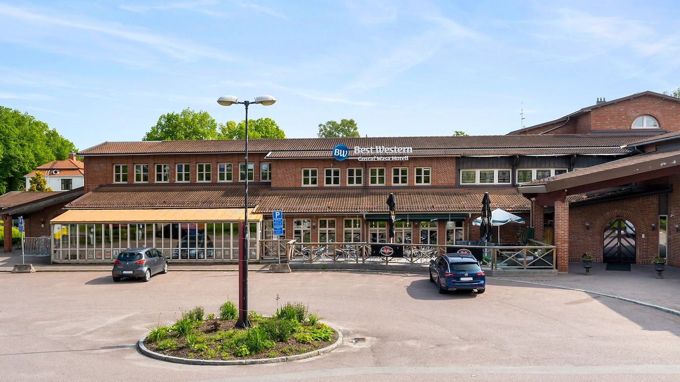 Fasaden av Best Western Gustaf Wasa Hotel i Borlänge. En stor tegelbyggnad, med en uteservering i förgrunden.
