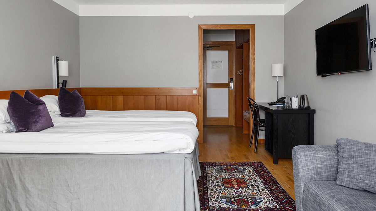 Ett familjerum på Best Western Gustaf Wasa Hotel i Borlänge med rymlig säng, en bäddsoffa, skrivbord och tv. 