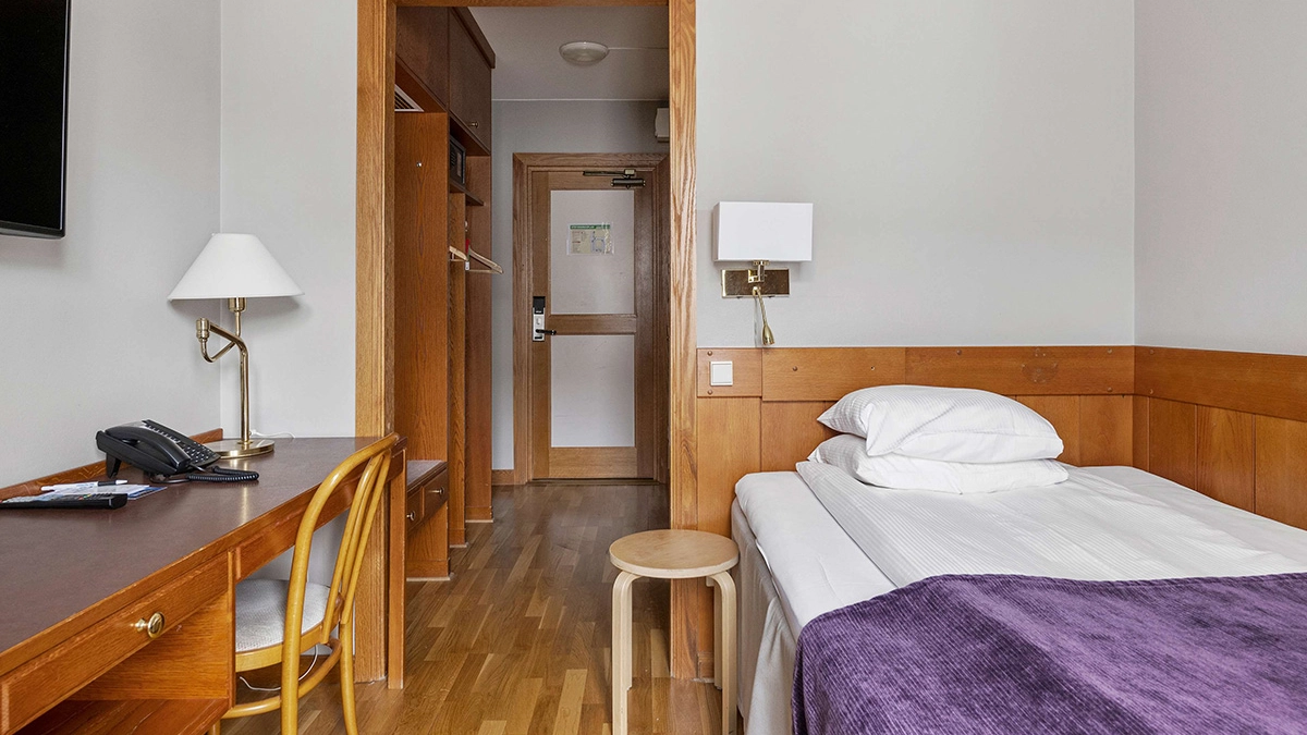 Ett enkelrum på Best Western Gustaf Wasa Hotel i Borlänge med säng och skrivbord.