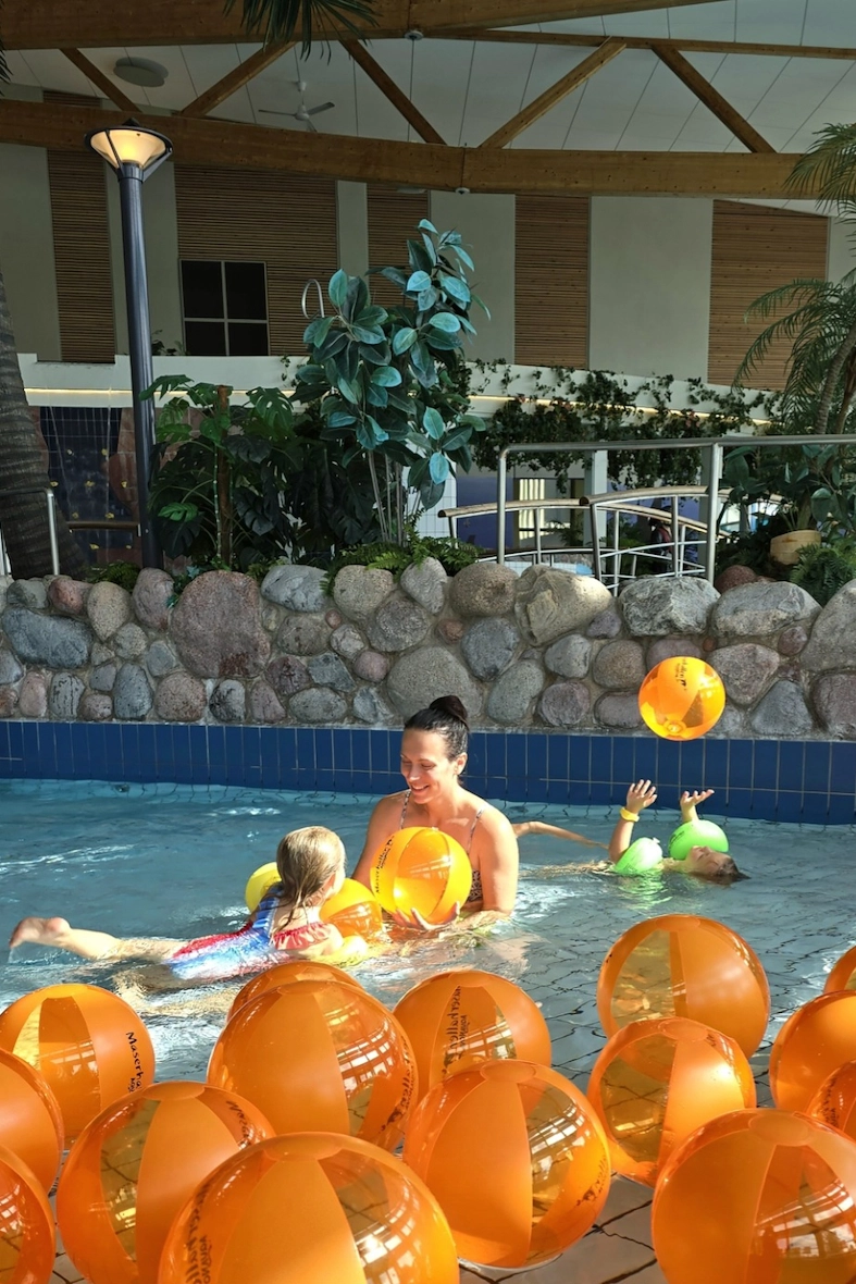 En kvinna som leker med två små barn inne på äventyrsbadet Aqua Nova i Borlänge.