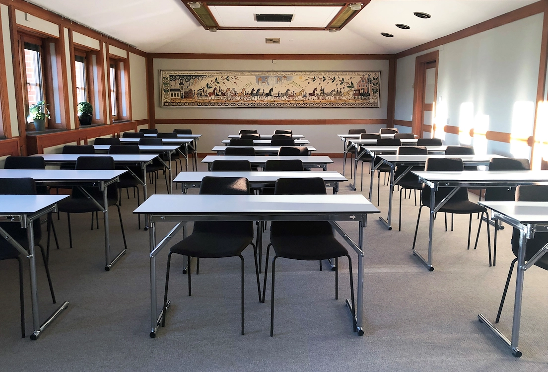 En bild från konferenslokalen Jussi Björling på Best Western Gustaf Wasa Hotel med skolsittning. I bakgrunden syns en tavla med hästar som drar vagnar i led.