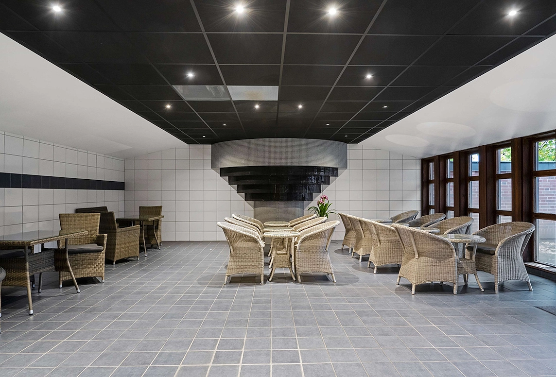 En del av relaxavdelningen på Best Western Gustaf Wasa Hotel med flera sittgrupper och klinker på golvet och väggarna.