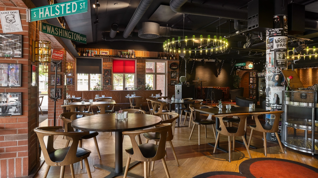 En del av restaurangen Broken Dreams. Mörka trämöbler, amerikanska vägskyltar och en liten scen syns i bakgrunden.