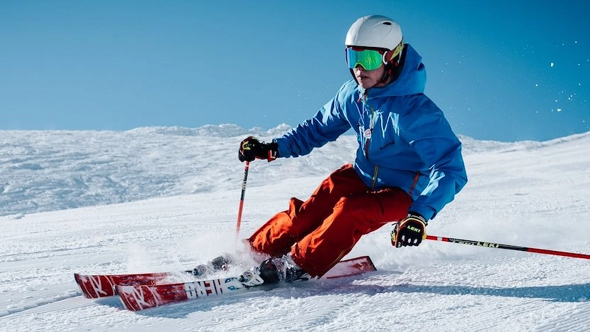 En bild på en person som åker skidor i en snöig backe.