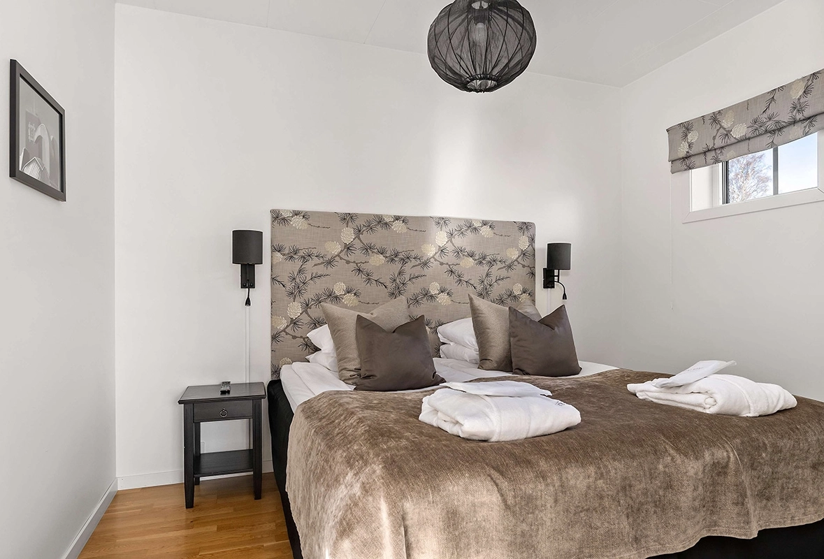 En lyxig och stor säng med badrockar prydligt vikta på fotändan.