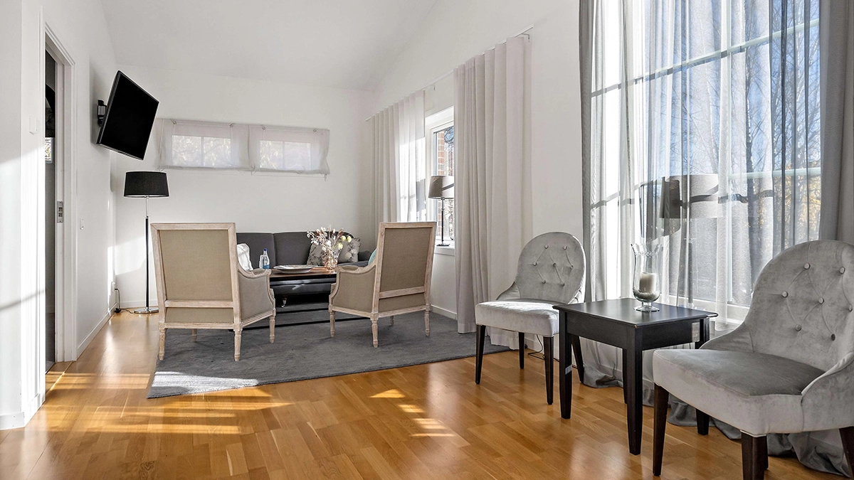 Wasasviten på Best Western Gustaf Wasa Hotel i Borlänge med eleganta stolar, en soffgrupp, stora fönster och tv. 