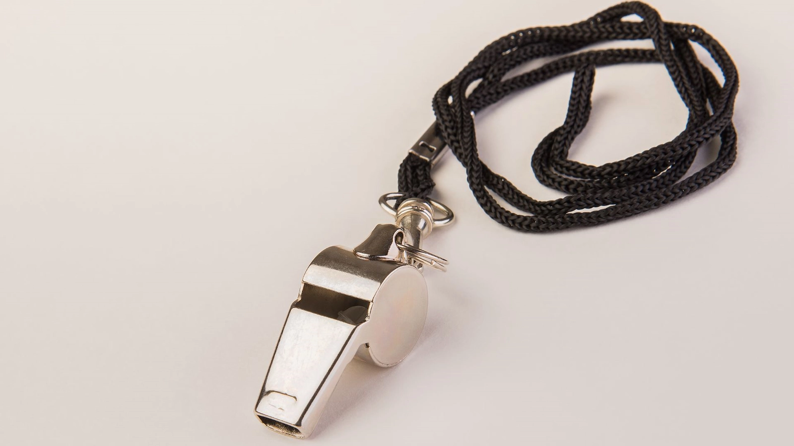 En visselpipa i metall med ett svart snöre.